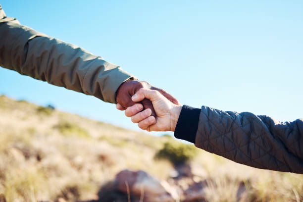 istock Friendship, help and men holding hands on a hike for support while climbing a rock on a mountain. Assistance, adventure and interracial male friends trekking together for fitness challenge in nature. 1483765602