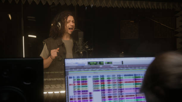 istock Female sound engineer works with singer in studio 1483767185