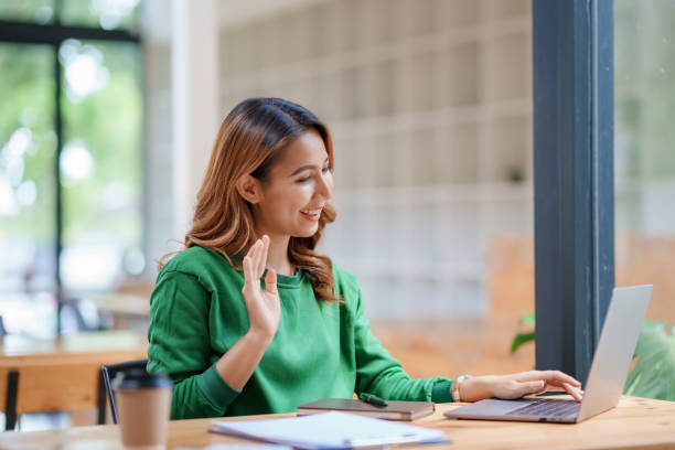 istock Beautiful young Asian woman college student is video chatting with her classmates using laptop, smiling faces and gestures happily studying. 1483767437