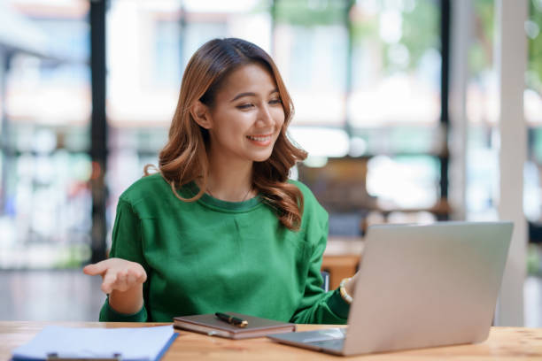 istock Beautiful young Asian woman college student is video chatting with her classmates using laptop, smiling faces and gestures happily studying. 1483767439