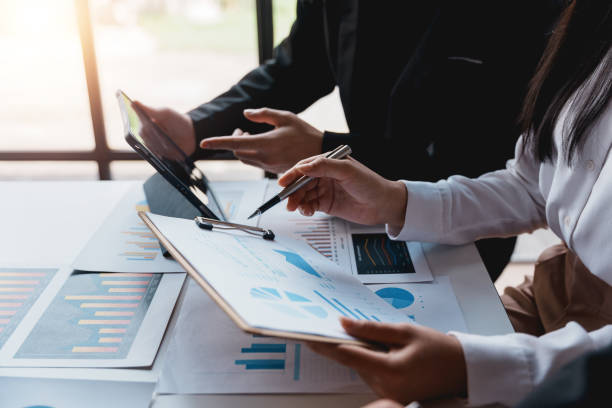 istock Businesspeople pointing to graphs and charts, thinking and analyzing various data in reports market growth to plan new sales strategies to increase productivity. 1483768456
