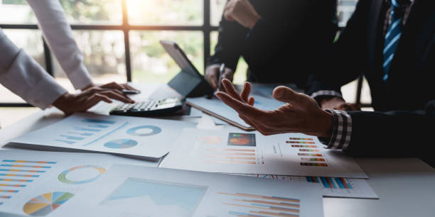 istock Businesspeople pointing to graphs and charts, thinking and analyzing various data in reports market growth to plan new sales strategies to increase productivity. 1483768469