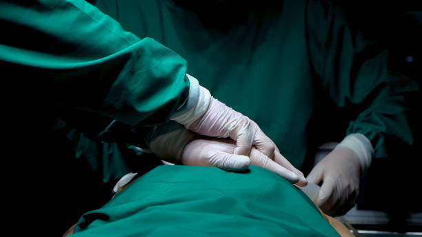 istock Doctor hands are intertwined on chest patient undergoing surgery his heart stops beating, doctor tried pump heart make patient recover urgently physician assistant wearing an oxygen mask patient. 1483768774