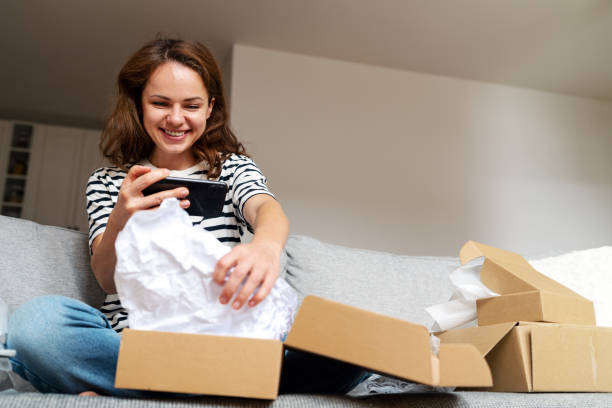 istock Woman unboxing parcel with purchase from online store  vlogging unpacking process for her social media. 1483772262