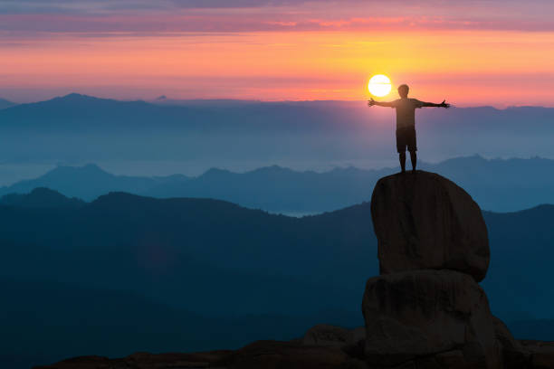 istock Hiker with backpack seeing the sunrise from a mountaintop while holding up his hands. 1483775134