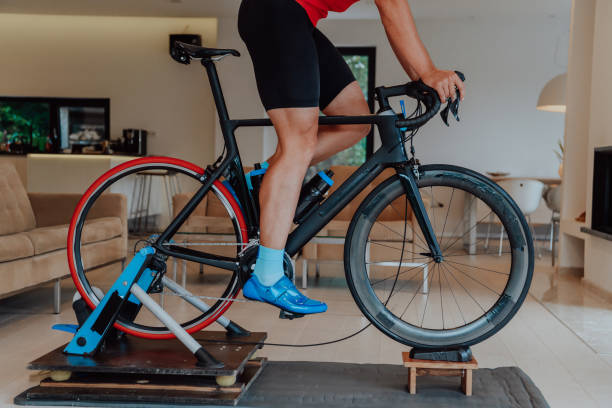 istock A man riding a triathlon bike on a machine simulation in a modern living room. Training during pandemic conditions. 1483778089