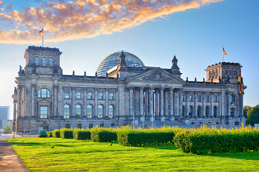 The Reichstag building seen from the former Königsplatz at sunrise in Berlin, Germany. Composite photo