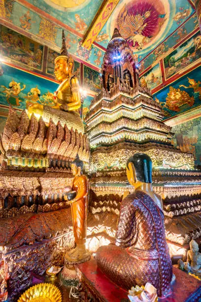 Important Khmer historical pagoda,surrounded by circular gardens,in the center of the city.Ornately decorated with large lit yellow wax candles and detailed vibrant designs and gold leaf patterns.
