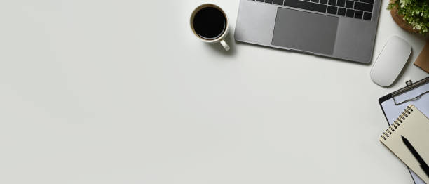 istock Flat lay, top view of white office desk with laptop computer, coffee cup and notebook. Copy space for advertise text. 1483782561