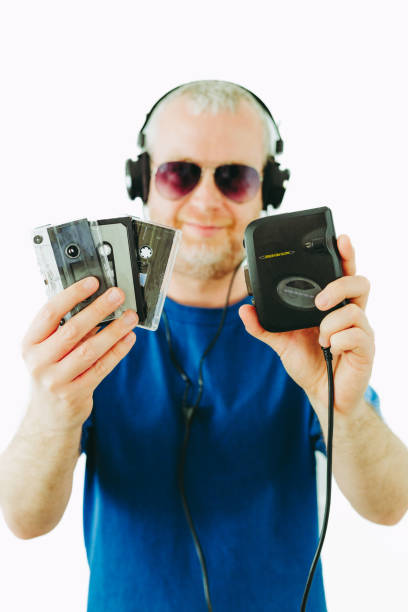 istock Man listening to retro portable cassette player while holding cassette tapes 1483784475