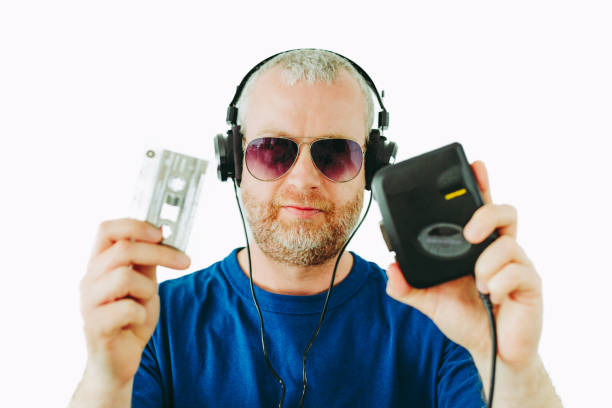 man listening to retro portable cassette player while holding cassette tapes - aviator glasses audio imagens e fotografias de stock