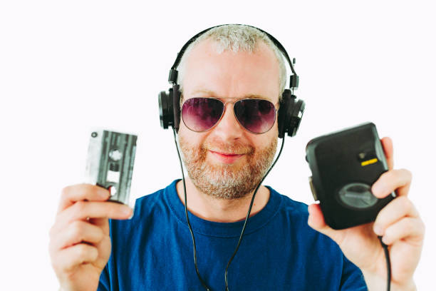 man listening to retro portable cassette player while holding cassette tapes - aviator glasses audio imagens e fotografias de stock