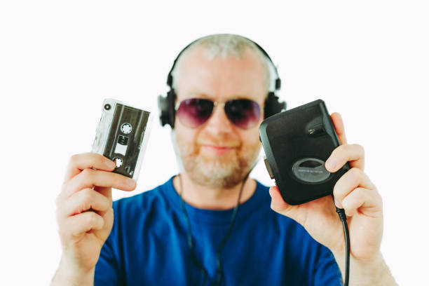 man listening to retro portable cassette player while holding cassette tapes - aviator glasses audio imagens e fotografias de stock