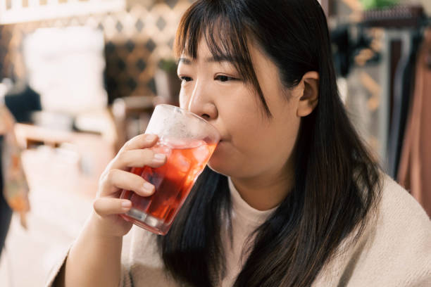 istock Young beautiful woman drinking juice 1483784804
