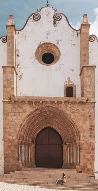 Tour tourism in Portugal,  woman sitting and enjoying cathedral of Silves- Travel in Algarve