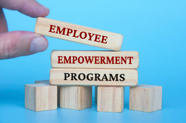 istock Hand placing employee empowerment programs text on wooden blocks with blue cover background. Employee empowerment concept. 1483791775