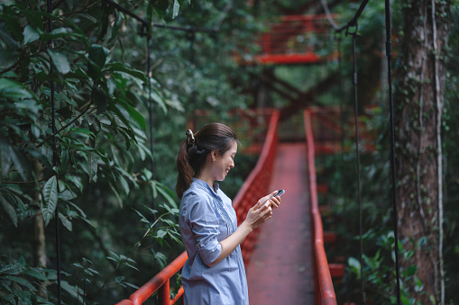 GEN-Z  tourist Asian travel using mobile phone adventure happiness moment Botanic Garden at trang thailand