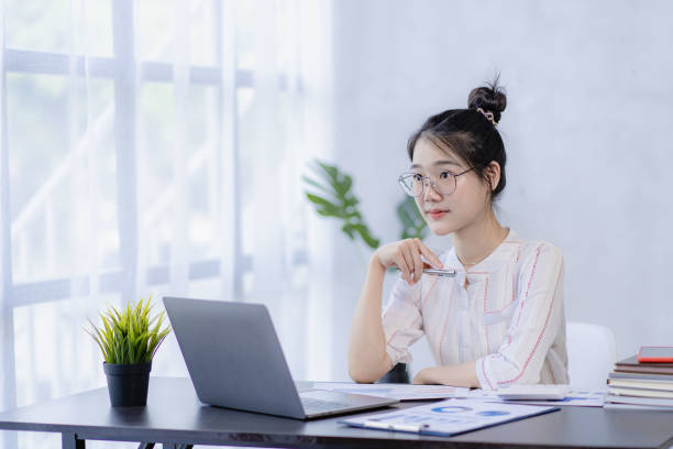 istock Pretty Asian woman using laptop while sitting at work concentrate on office work as an accountant Startup Business Executive Young female business leaders startup business ideas 1483794218