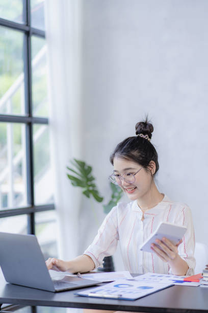 istock Pretty Asian woman using laptop while sitting at work concentrate on office work as an accountant Startup Business Executive Young female business leaders startup business ideas 1483794219