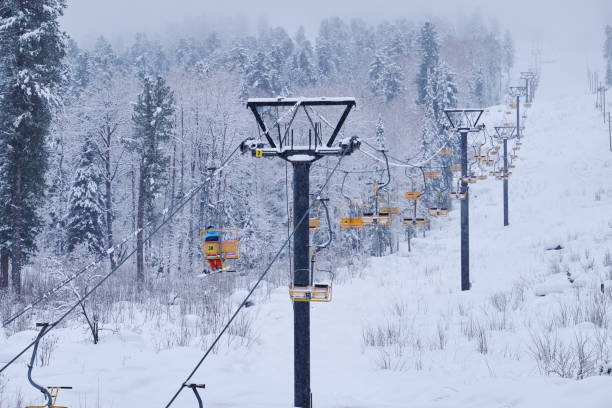 Teletsky Altai winter mountain ski resort near Iogach. Elevator on mount and forest background under snowfall stock photo