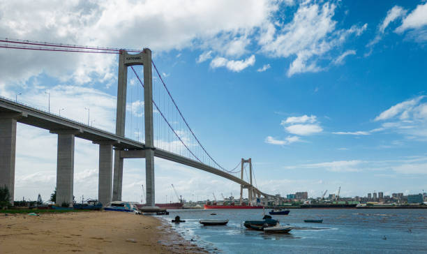 zdjęcie na plaży w pobliżu mostu z miastem w tle i terminalem portowym z łodziami ładowanymi w maputo w mozambiku. - rowboat fishing africa fishing industry zdjęcia i obrazy z banku zdjęć