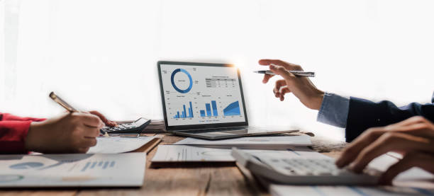 istock Business People Meeting using laptop computer,calculator,notebook,stock market chart paper for analysis Plans to improve quality next month. Conference Discussion Corporate Concept 1483799177