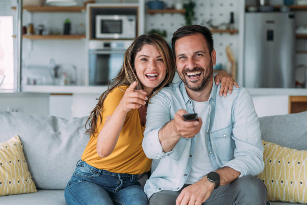 istock Cute young couple cuddling while watching tv. 1483802356