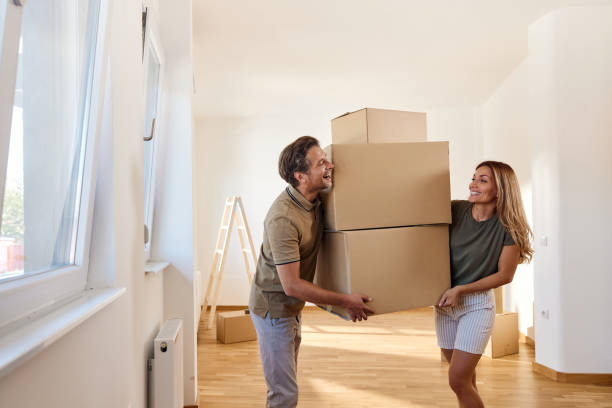 istock Happy couple carrying boxes after moving into a new home. 1483804247