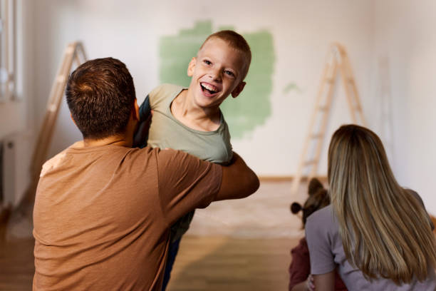 istock Playful siblings running into parents' hug during home renovation process. 1483804320