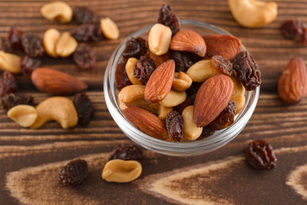 istock Various nuts in glass plate on wooden table 1483805249