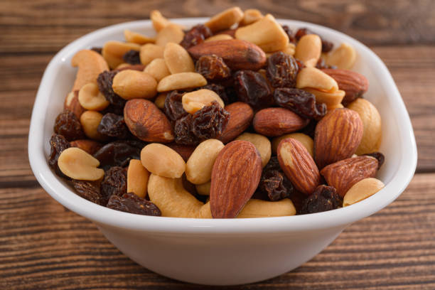 istock Various nuts in white plate close up on wooden table 1483805261