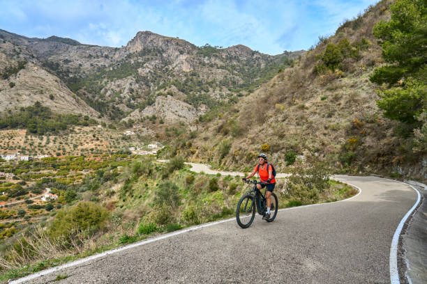 woman cycling in the Sierra de Tejada near Nerja, Andalusia, Spain stock photo