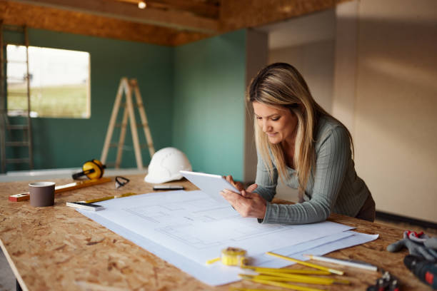 istock Female architect surfing the Internet on digital tablet at construction site. 1483808900