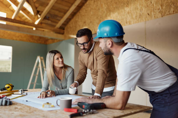 istock Young couple talking about housing design with manual worker. 1483809519