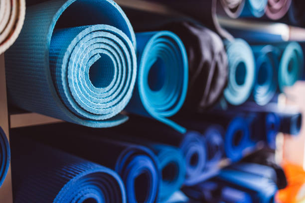 Blue yoga mats rolled up on shelves in the studio stock photo