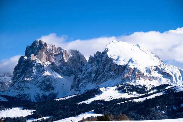istock Snow-covered mountain range under a blue sky with clouds in Alpe di Siusi, Italy. 1483813513