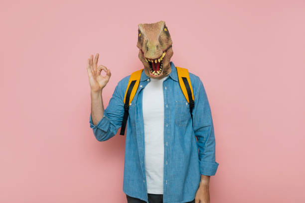 istock Man with backpack and lizard mask on pink background. 1483814987
