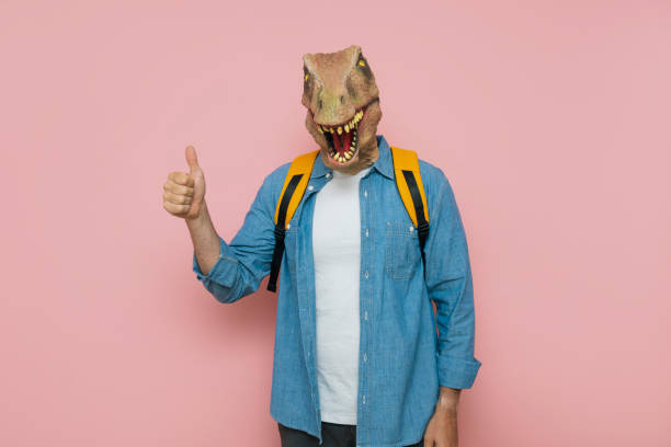 istock Man with backpack and lizard mask on pink background. 1483814990