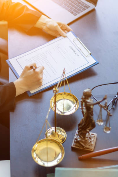 istock Lawyer holding contract documents in hand and preparing to sign a consulting contract for a team of business people who need legal advice to run their business in accordance with the law 1483815308