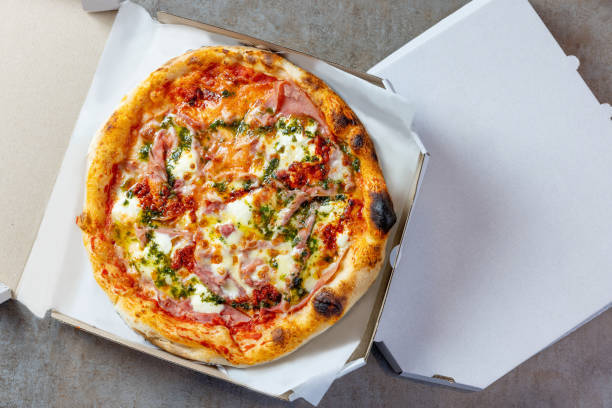 istock Fresh round baked Ham & Cheese pizza in open pizza box 1483818157
