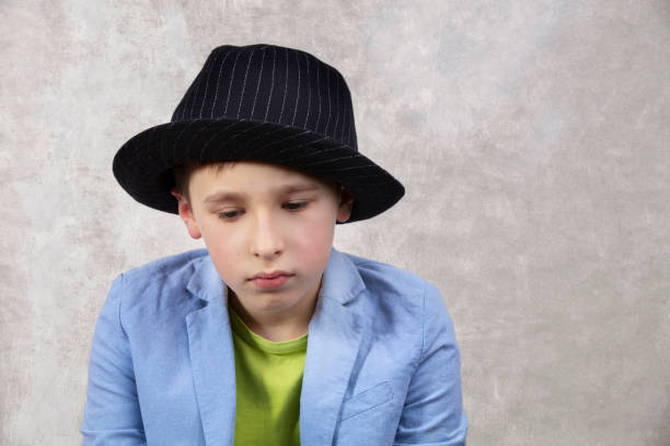 Sad boy in a suit and black hat.