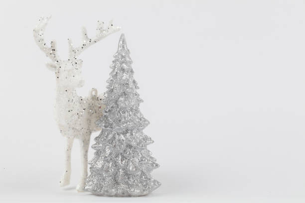 istock Muted holiday background. On a gray background, a silver tree and a white Christmas deer. 1483820937