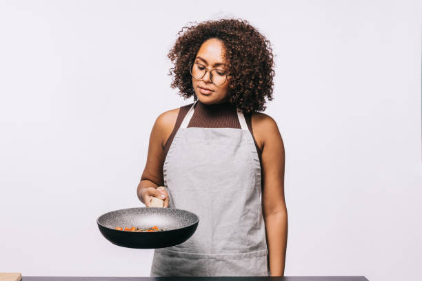 istock Young woman cooking a meal on white background 1483826536