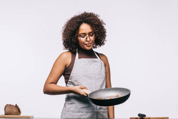 istock Young woman cooking a meal on white background 1483826538