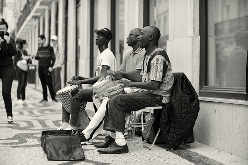 Lisbon, Portugal - October 29, 2022: A trio of arfican street musicians play percussion at the Rua Augusta street in Lisbon downtown.