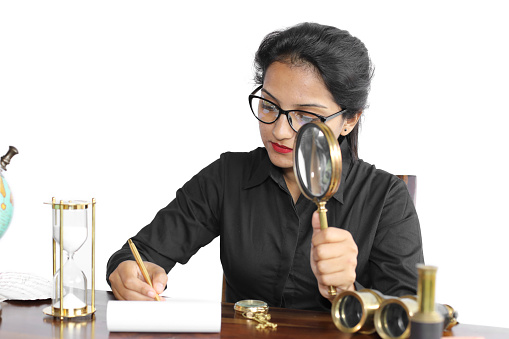 Female archaeologist writing notes in a journal.