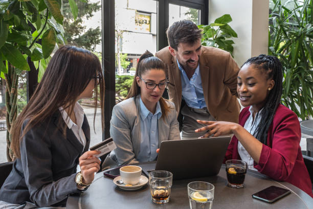 istock Young senior web developers small company owners new to the job market, developing a new internet application for a banking credit card payment system, sitting in a cafeteria working on a coffee break 1483833197