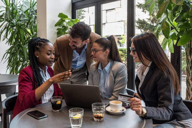 istock Young senior web developers small company owners new to the job market, developing a new internet application for a banking credit card payment system, sitting in a cafeteria working on a coffee break 1483833199