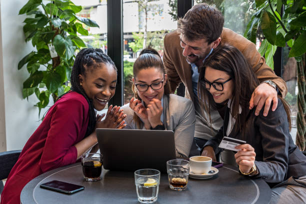 istock Young senior web developers small company owners new to the job market, developing a new internet application for a banking credit card payment system, sitting in a cafeteria working on a coffee break 1483833204