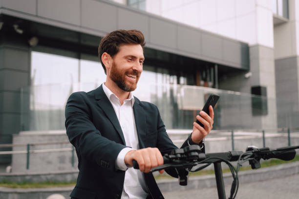 istock Caucasian Man in formal suit paying for scooter rent using mobile application, stand with smartphone waiting. People lifestyle, modern transportation, vehicle. Side view portrait. Success, business 1483833981